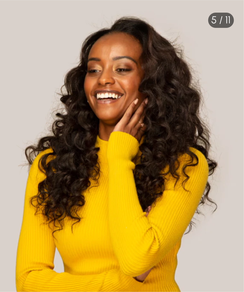 Pretty woman wearing virgin body wave bundles wearing yellow sweater arms folded with white background